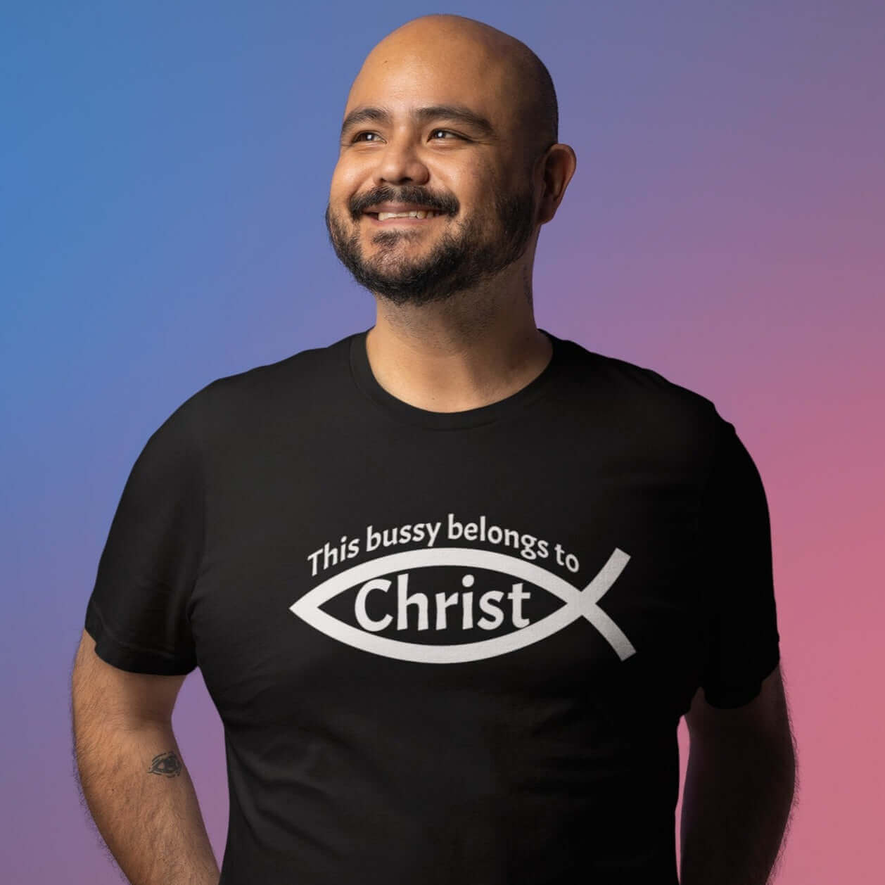 Man wearing black t-shirt with This bussy belongs to Christ inside of a Christian fish symbol printed on the front.