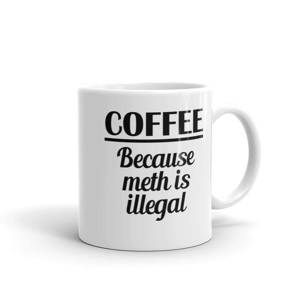 White ceramic coffee mug with the funny phrase Coffee because meth is illegal printed on both sides of the mug.
