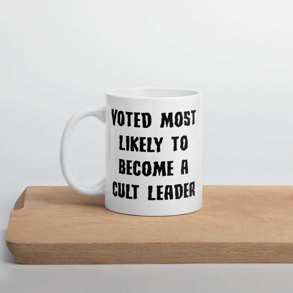 White ceramic mug with the words Voted most likely to become a cult leader printed on both sides.
