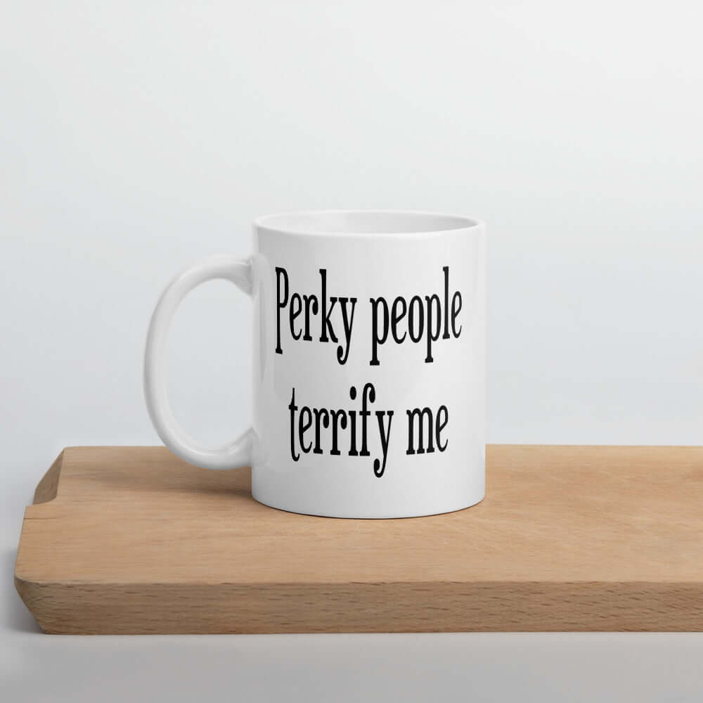 White ceramic coffee mug with the phrase Perky people terrify me printed on both sides.