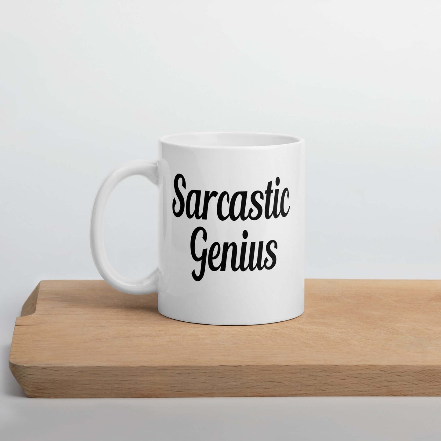 White ceramic coffee mug with the words Sarcastic Genius printed on both sides of the mug.