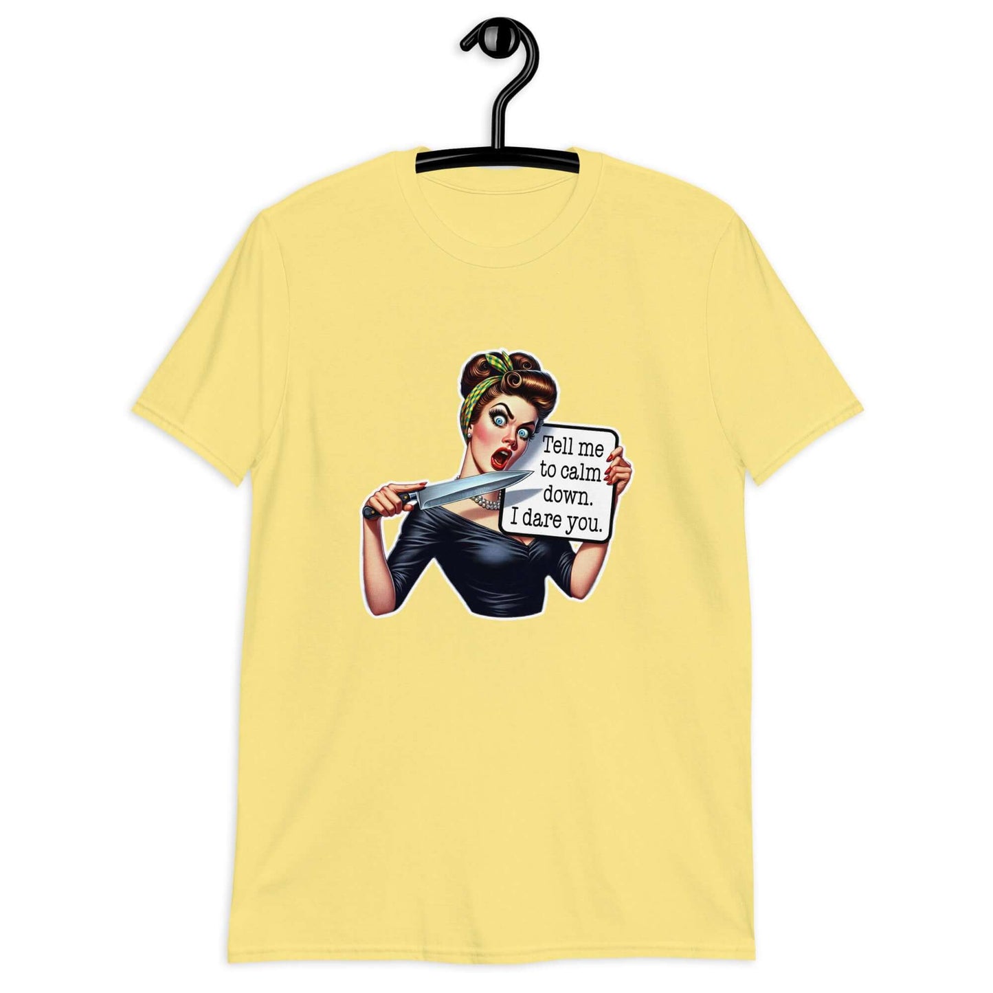 Cornsilk yellow t-shirt displayed on a hanger. The t-shirt has a graphic of an angry looking retro woman holding a knife and a sign. The sign says Tell me to calm down I dare you. The graphic is printed on the front of the shirt.