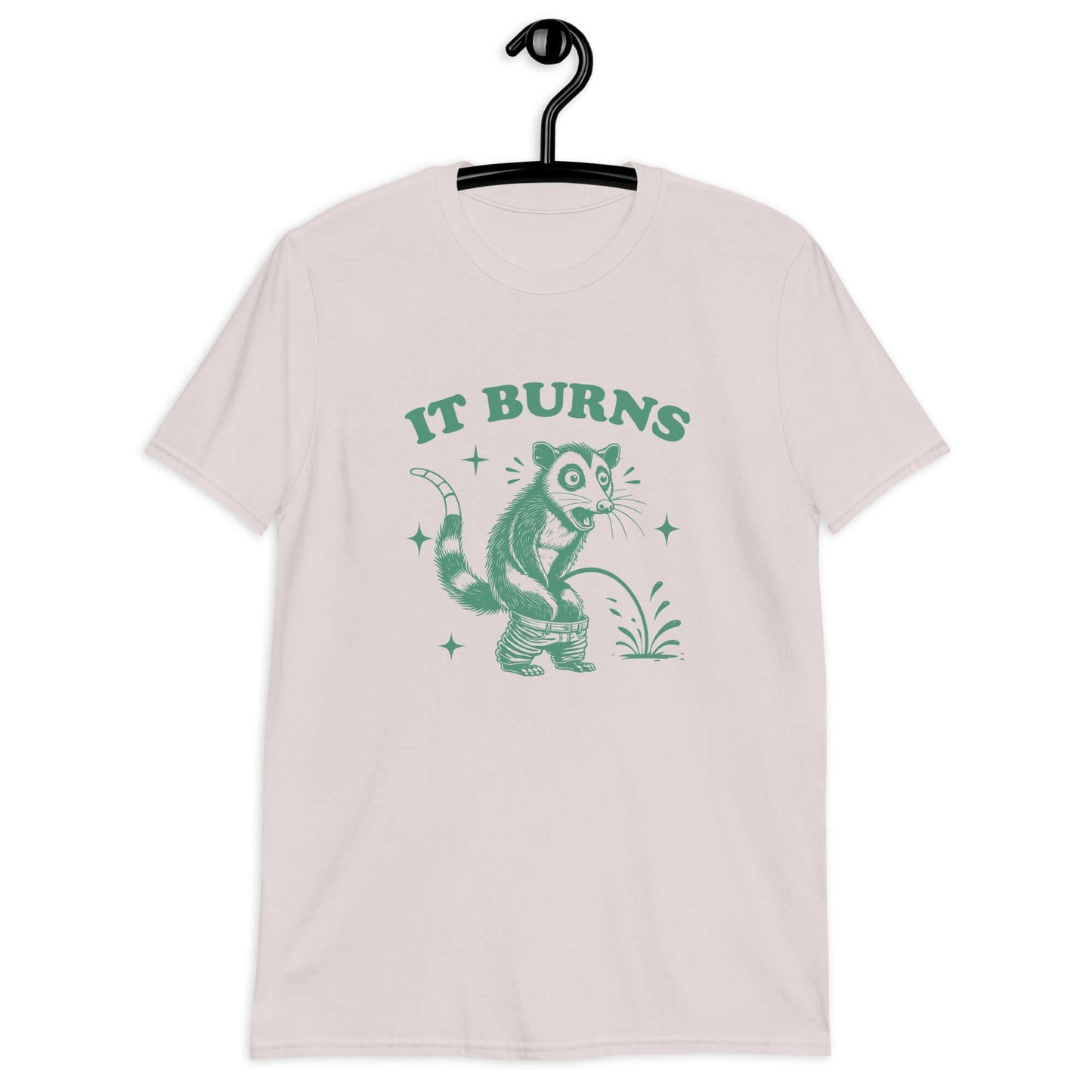 Ice grey color t-shirt with an image of an opossum peeing. The words It burns are printed above.