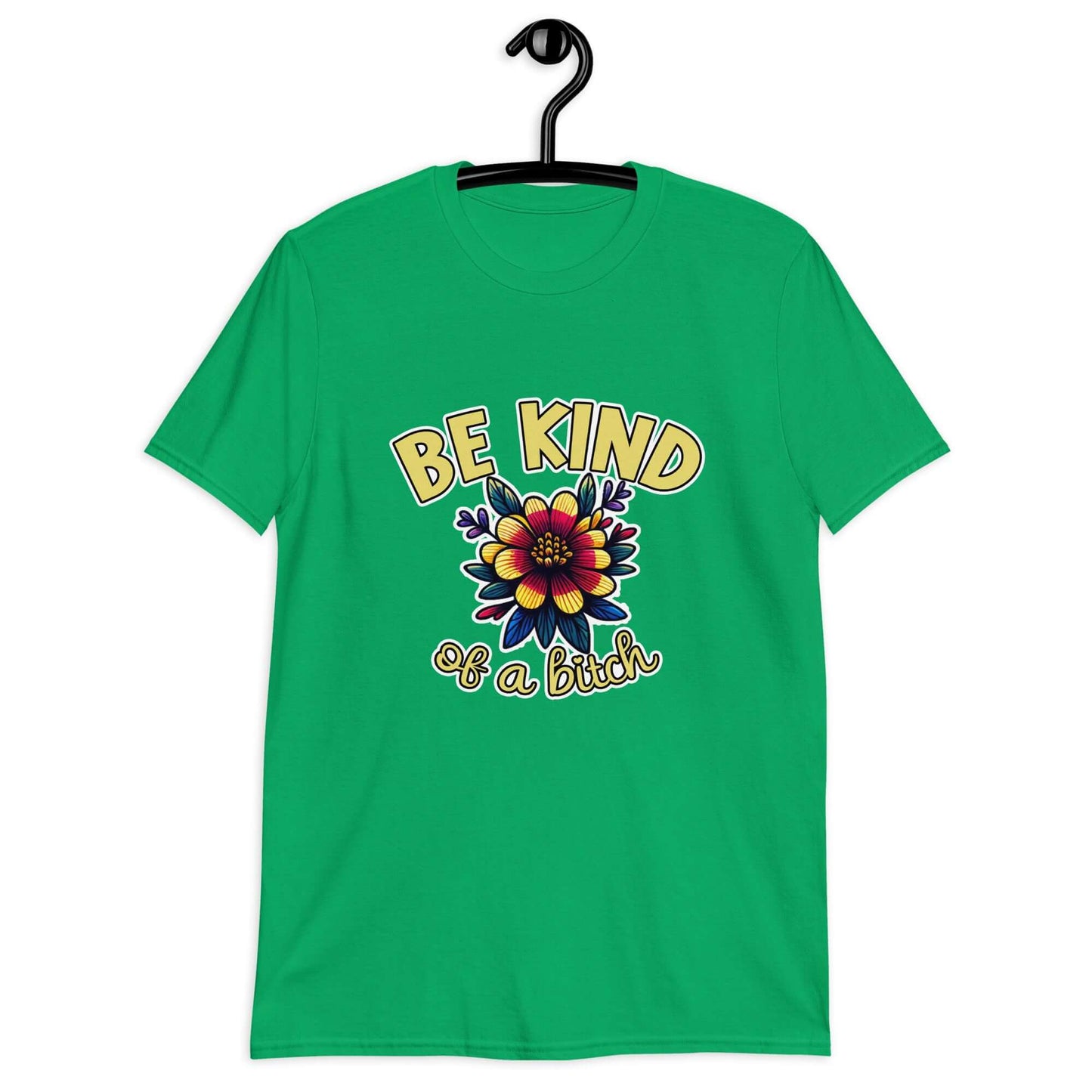 Irish green t-shirt with an image of a flower and the words Be kind above the flower in yellow bold block font. The words Of a bitch are smaller in script font under the flower. The design is printed on the front of the shirt.