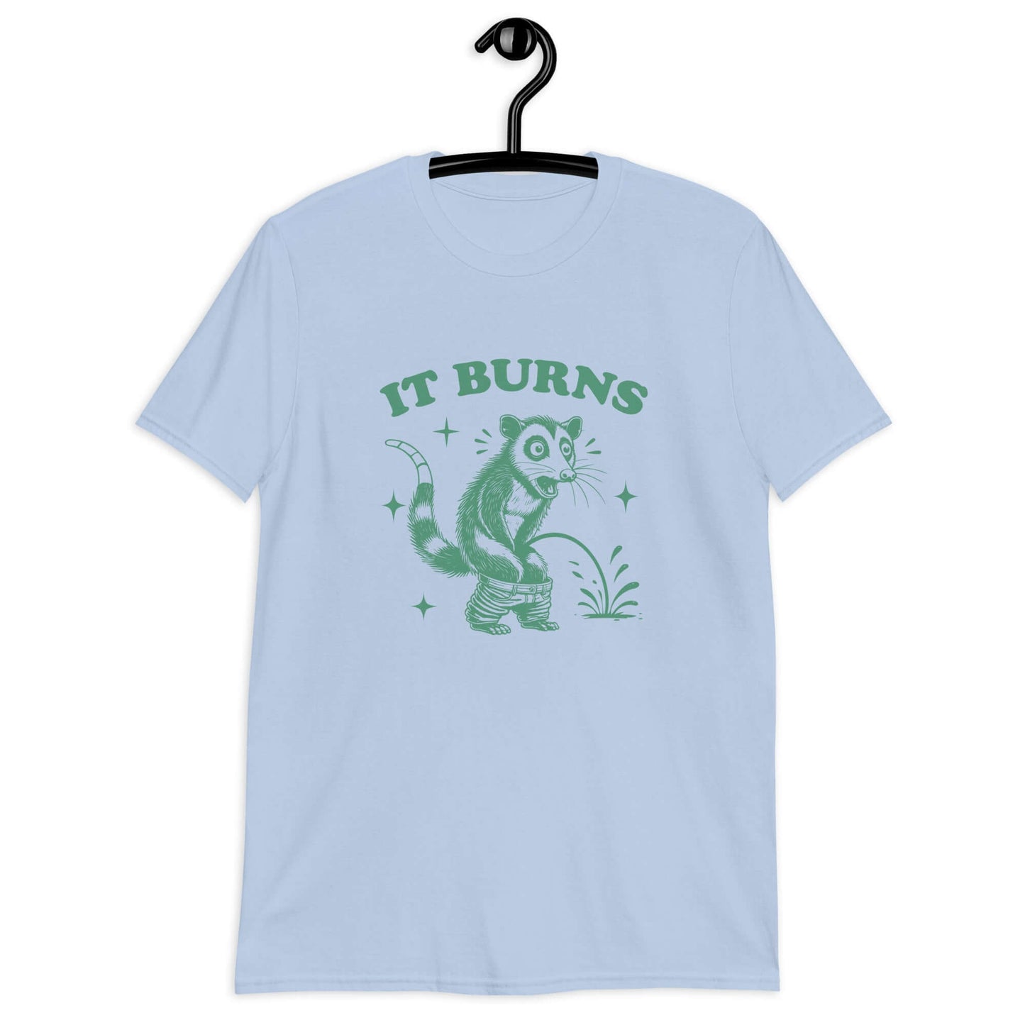 Light blue t-shirt with an image of an opossum peeing. The words It burns are printed above.
