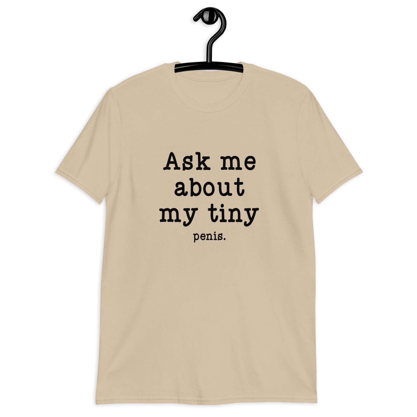 Sand color t-shirt with the phrase Ask me about my tiny penis printed on the front. The word penis is much smaller than the rest of the text.