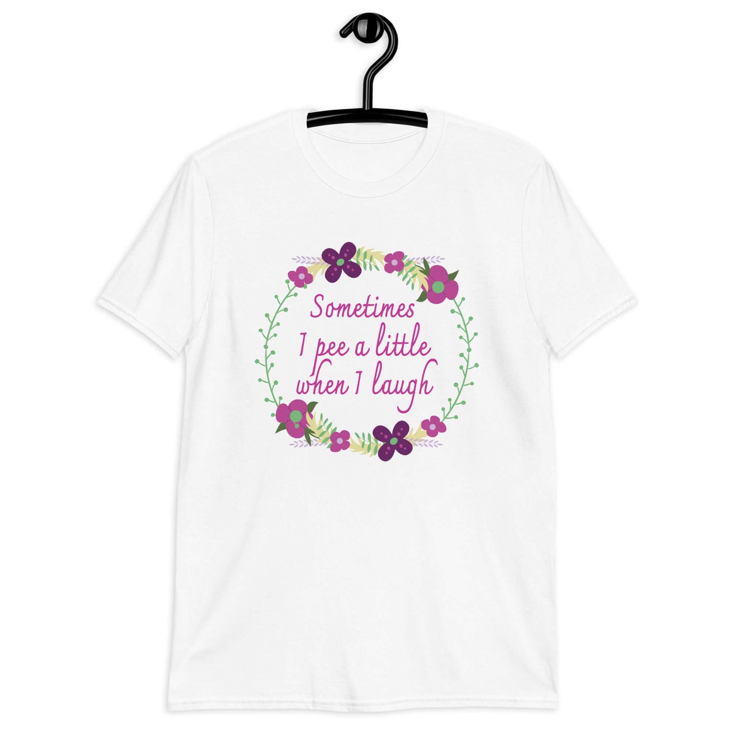 White t-shirt that has a minimalistic style line drawing floral wreath with the phrase Sometimes I pee a little when I laugh printed in the center of the wreath. The graphics are printed on the front of the shirt.