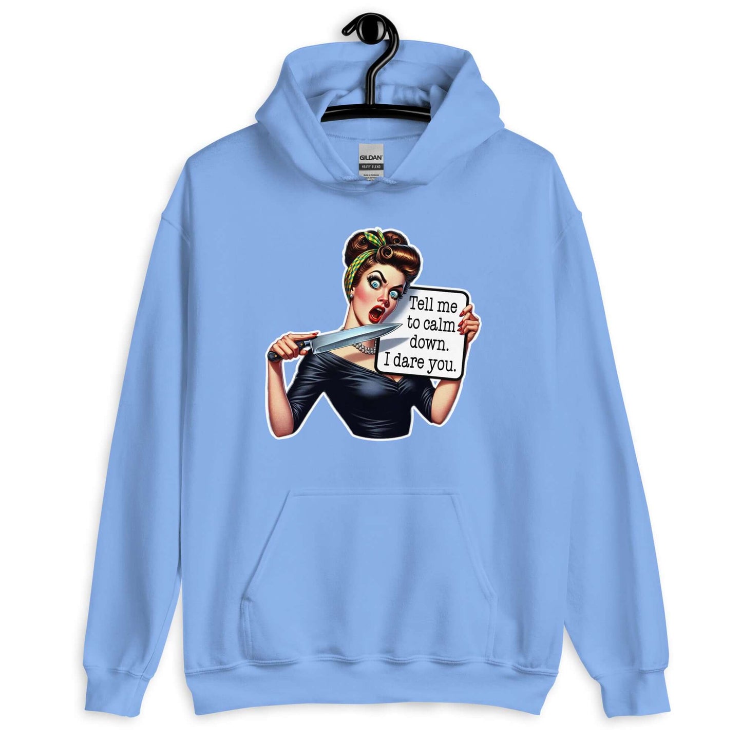Carolina blue hoodie sweatshirt displayed on a hanger. The sweatshirt has a graphic of an angry looking retro woman holding a knife and a sign. The sign says Tell me to calm down I dare you. The graphic is printed on the front of the hoodie.