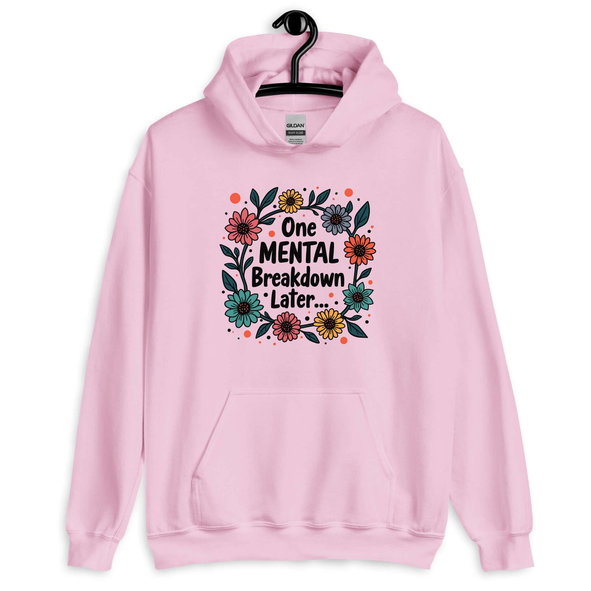 Light pink hoodie sweatshirt with a multi color floral wreath design printed on the front. The words One mental breakdown later are printed in the center of the wreath.