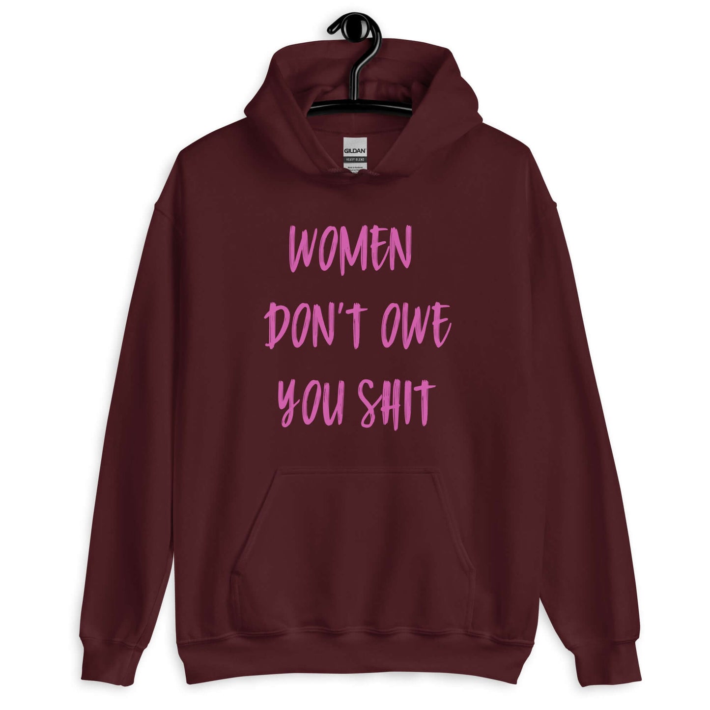 Maroon hoodie sweatshirt with the words Women don't owe you shit printed on the front in pink.
