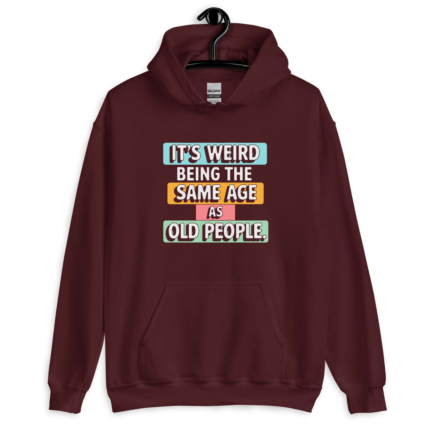 Maroon hoodie sweatshirt with colorful graphics that say It's weird being the same age as old people printed on the front.