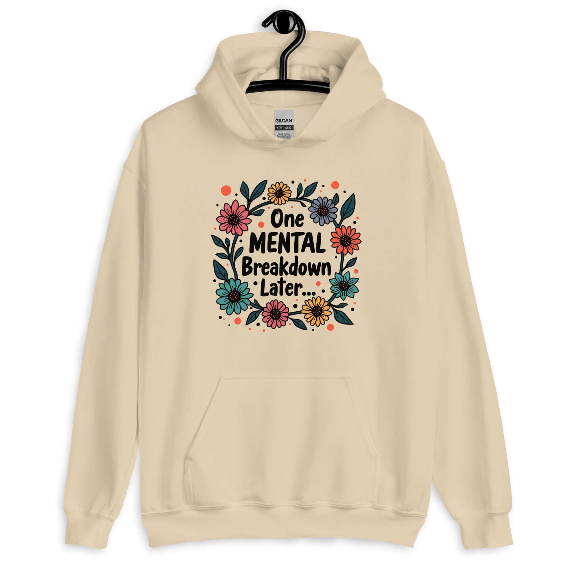 Sand color hoodie sweatshirt with a multi color floral wreath design printed on the front. The words One mental breakdown later are printed in the center of the wreath.