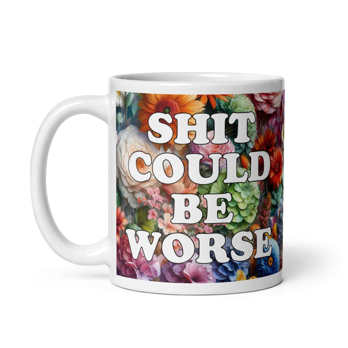 White ceramic mug floral background and the words Shit could be worse printed on both sides.