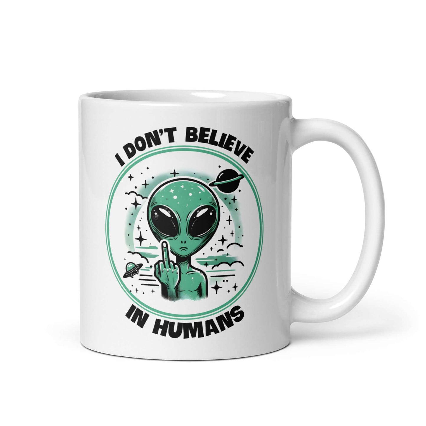 White ceramic mug with an image of an alien flipping the middle finger. The words I don't believe in humans are printed around the image. The graphics are printed on both sides of the mug.