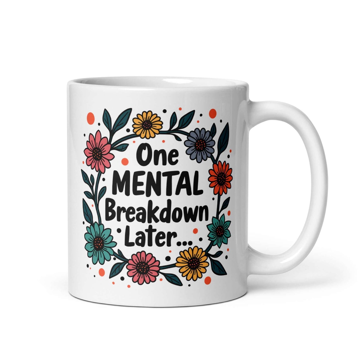 White ceramic mug with a multi color floral wreath design printed on it. The words One mental breakdown later are printed in the center of the wreath. The graphics are printed on both sides of the mug.