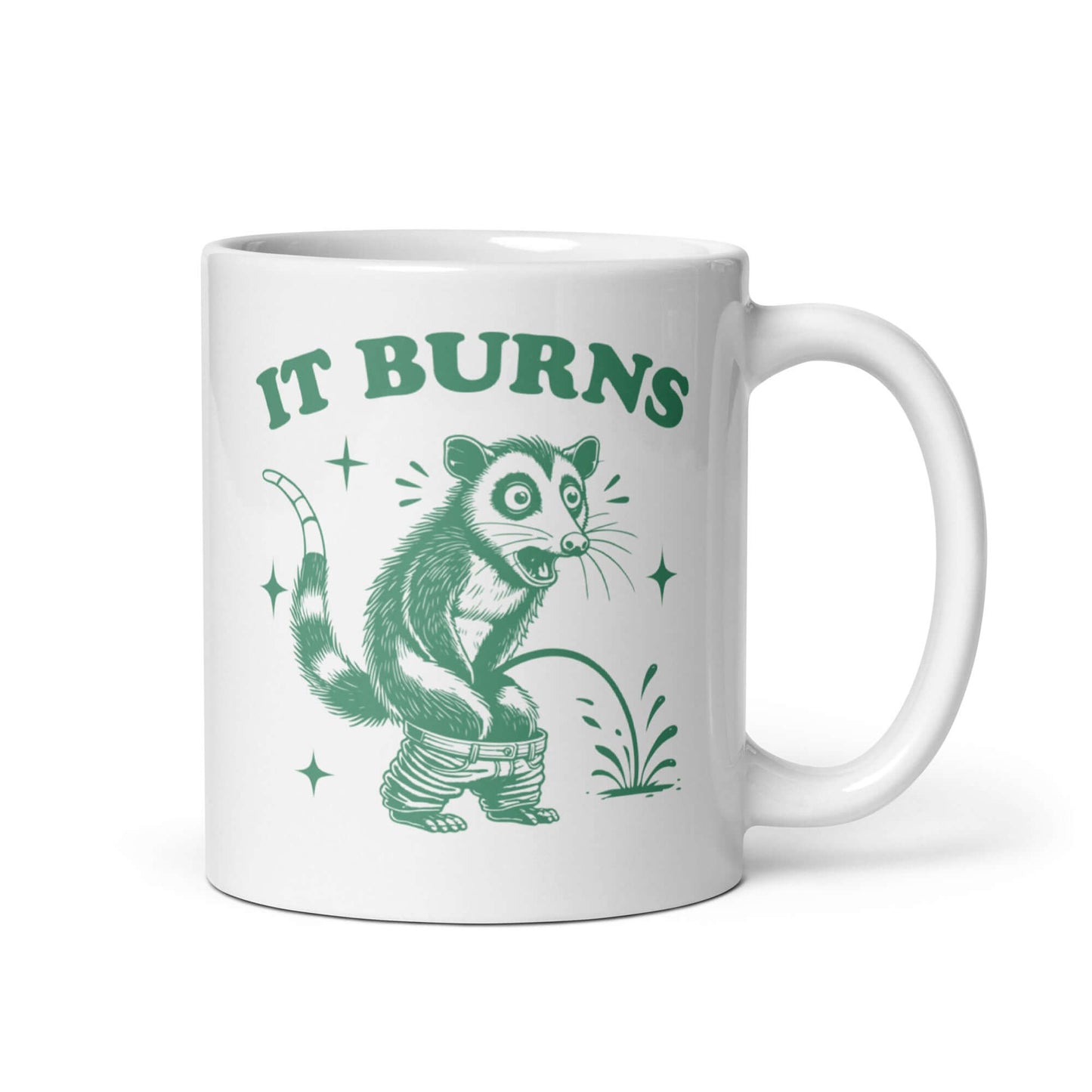 White ceramic mug with an image of an opossum peeing. The words It burns are printed above.
