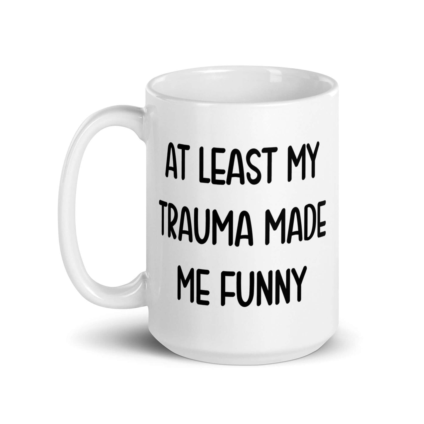 White ceramic mug with the words At least my trauma made me funny printed on both sides.