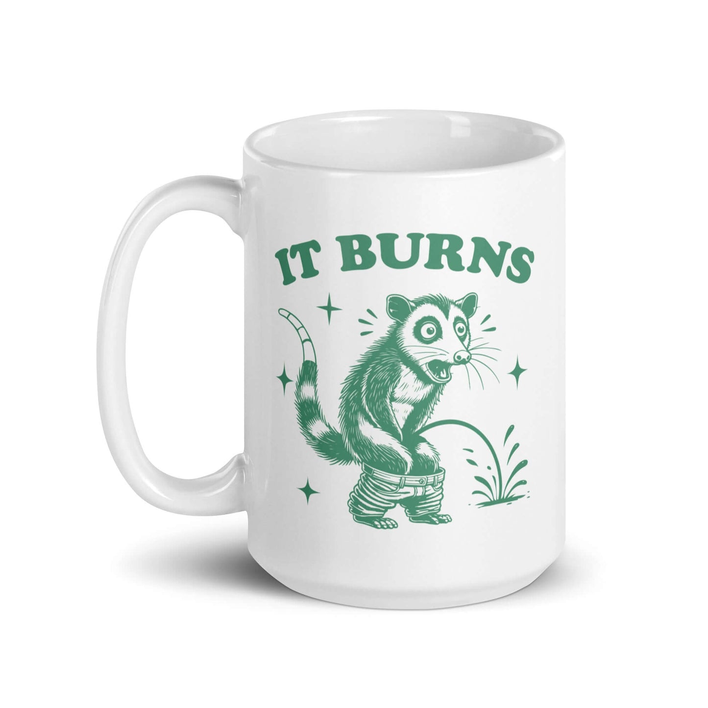 White ceramic mug with an image of an opossum peeing. The words It burns are printed above.