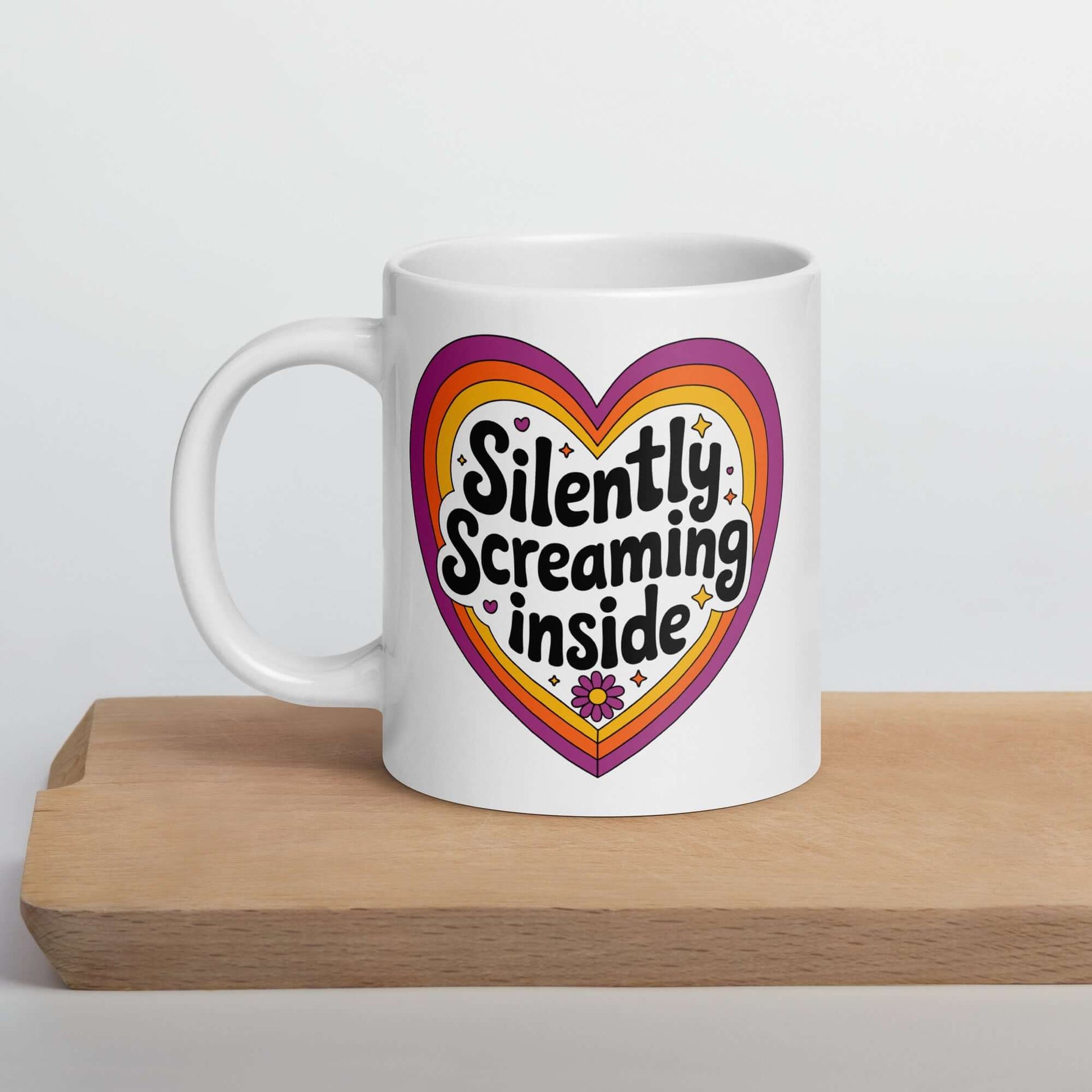White ceramic coffee mug with a graphic that says Silently screaming inside. The graphics are printed on both sides of the mug.