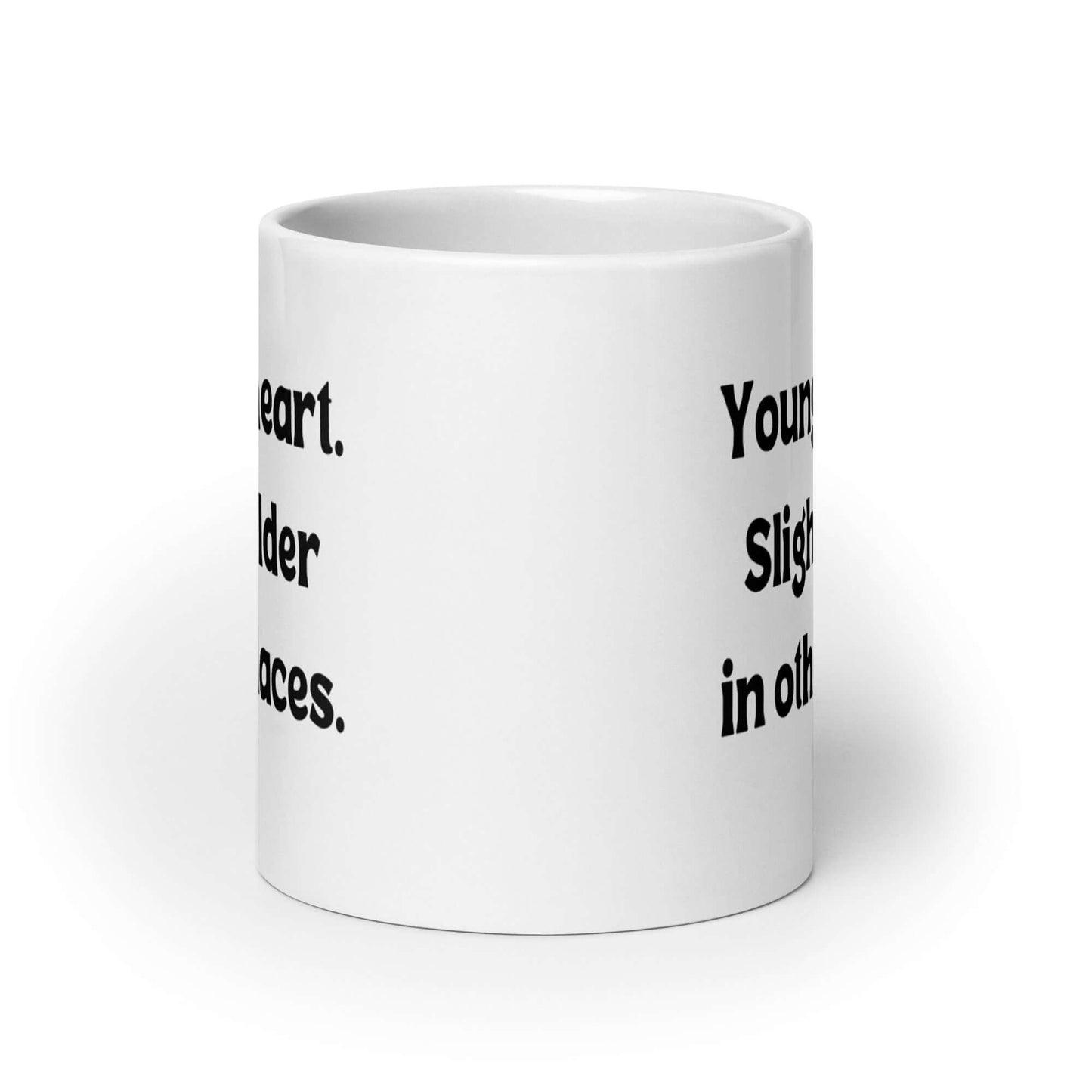 White ceramic mug with the words Young at heart, slightly older in other places printed on both sides.