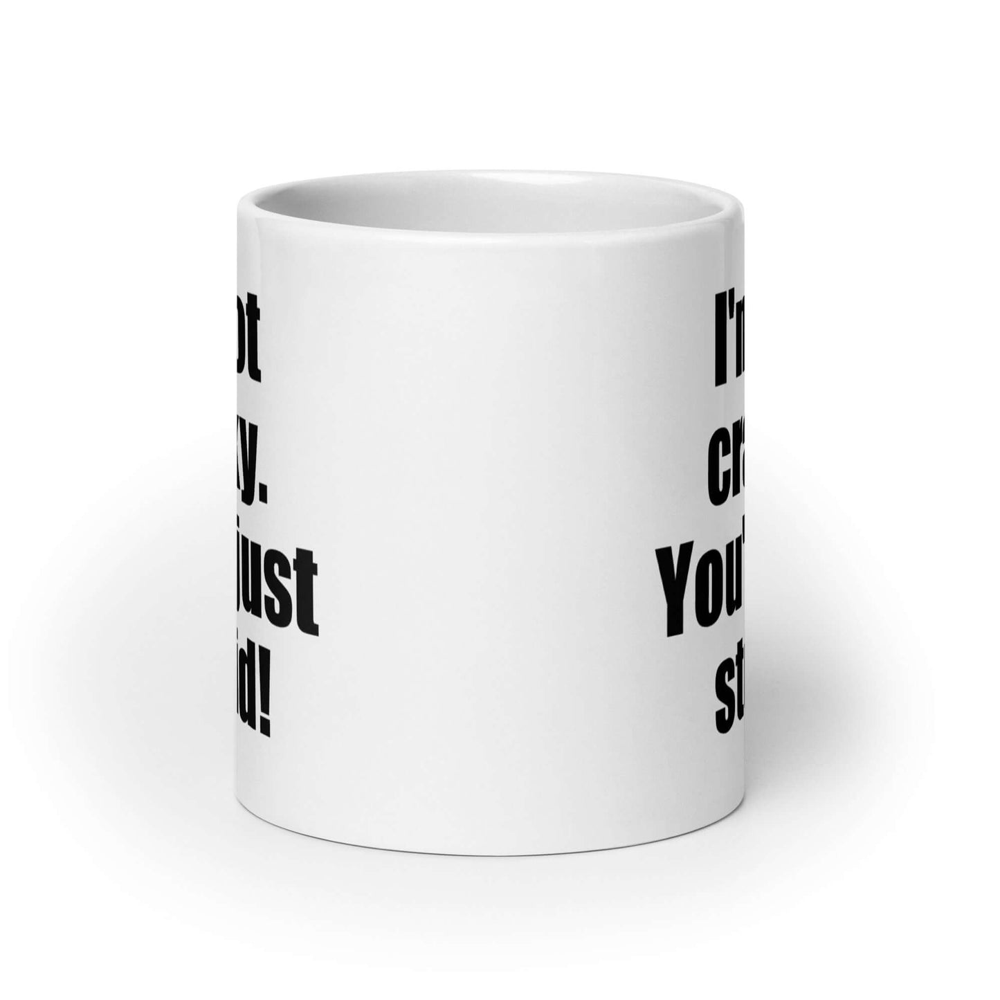 White ceramic coffee mug with the phrase I'm not cranky You're just stupid printed on both sides of the mug.
