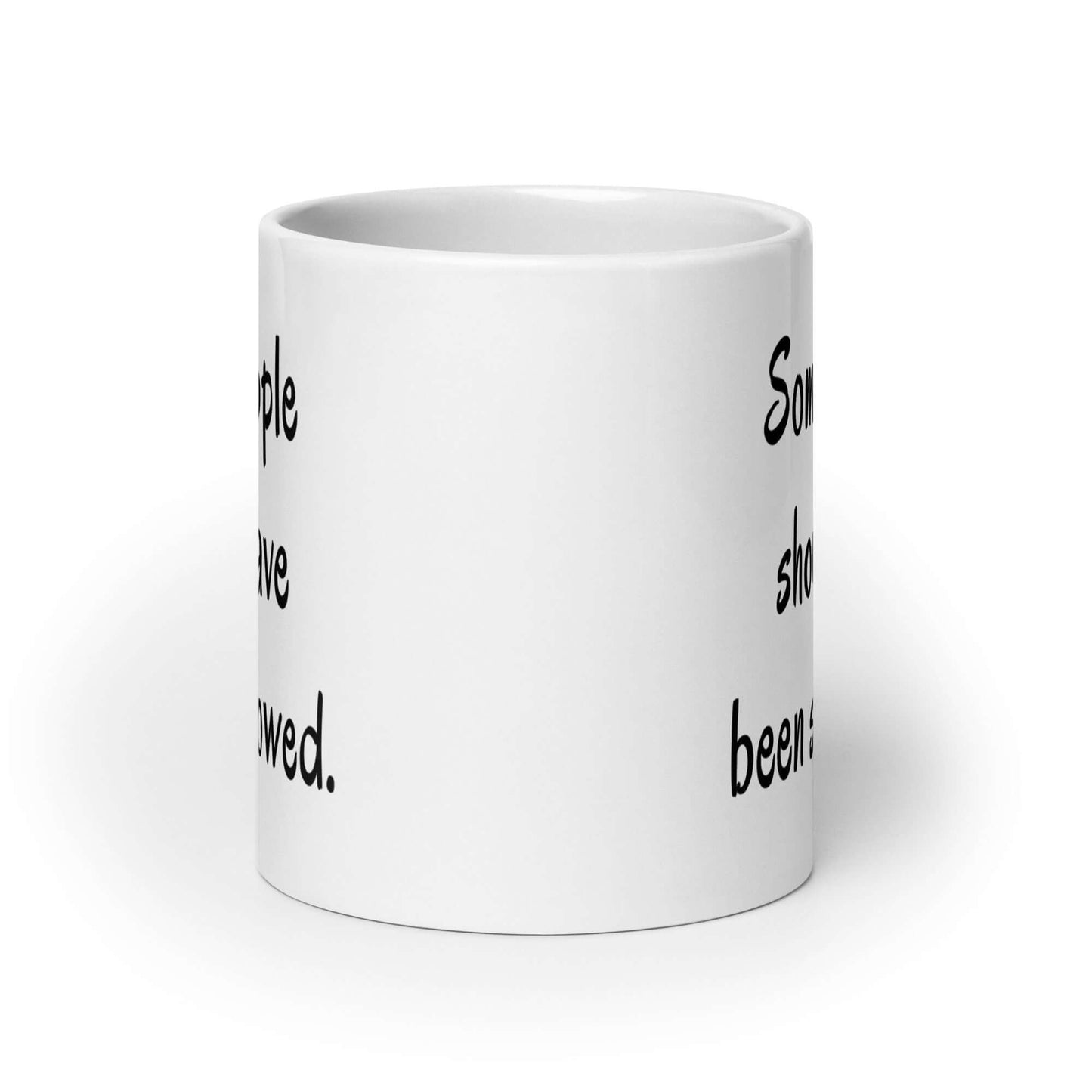 White ceramic coffee mug with the phrase some people should have been swallowed printed on both sides.