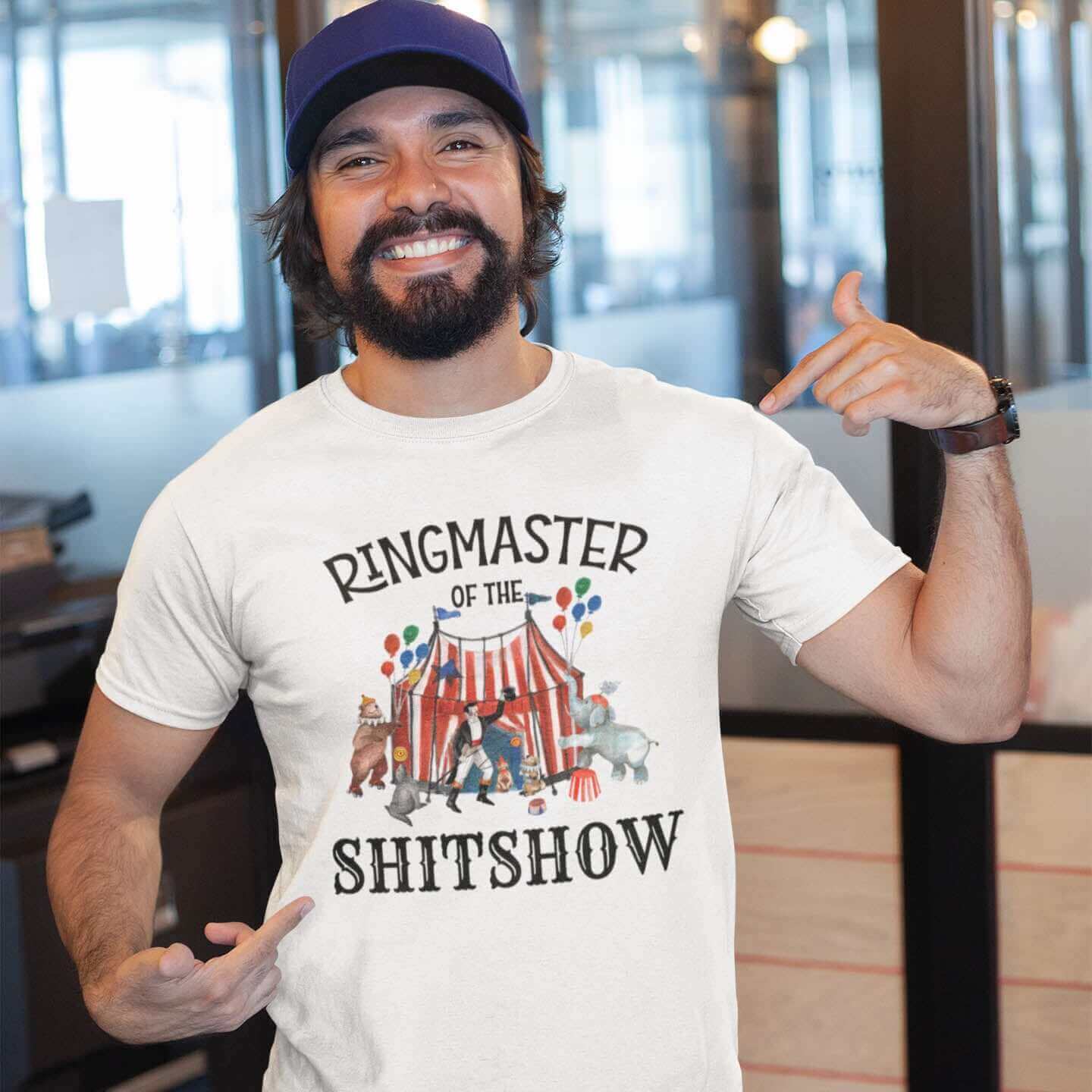 Man wearing a white t-shirt with a circus theme graphic and the words Ringmaster of the Shitshow printed on the front.
