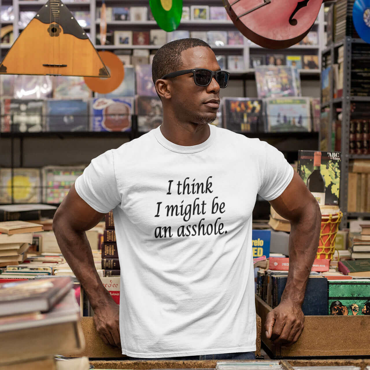 Man wearing sunglasses and a white t-shirt with the phrase I think I might be an asshole printed on the front.