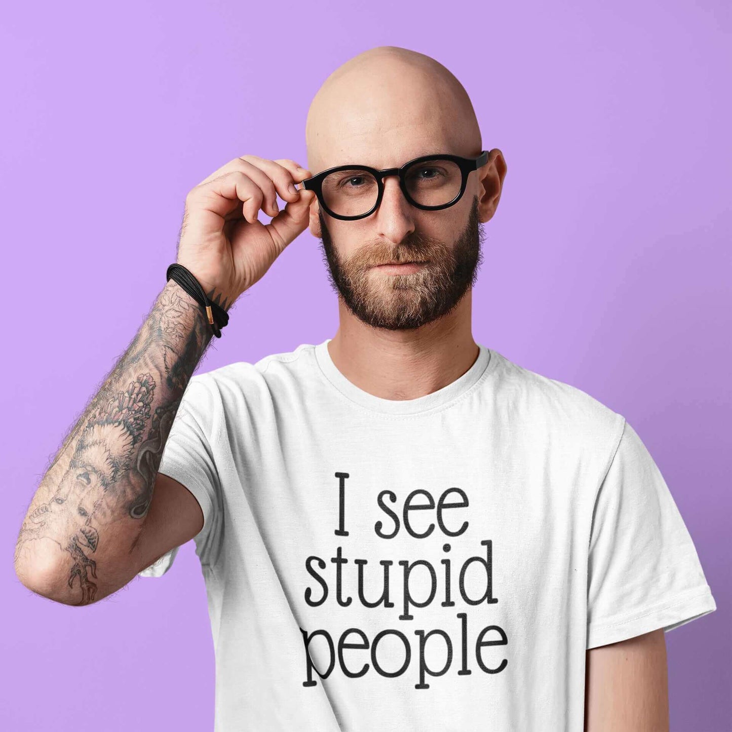 Man wearing glasses wearing a white t-shirt that has the words I see stupid people printed on the front.