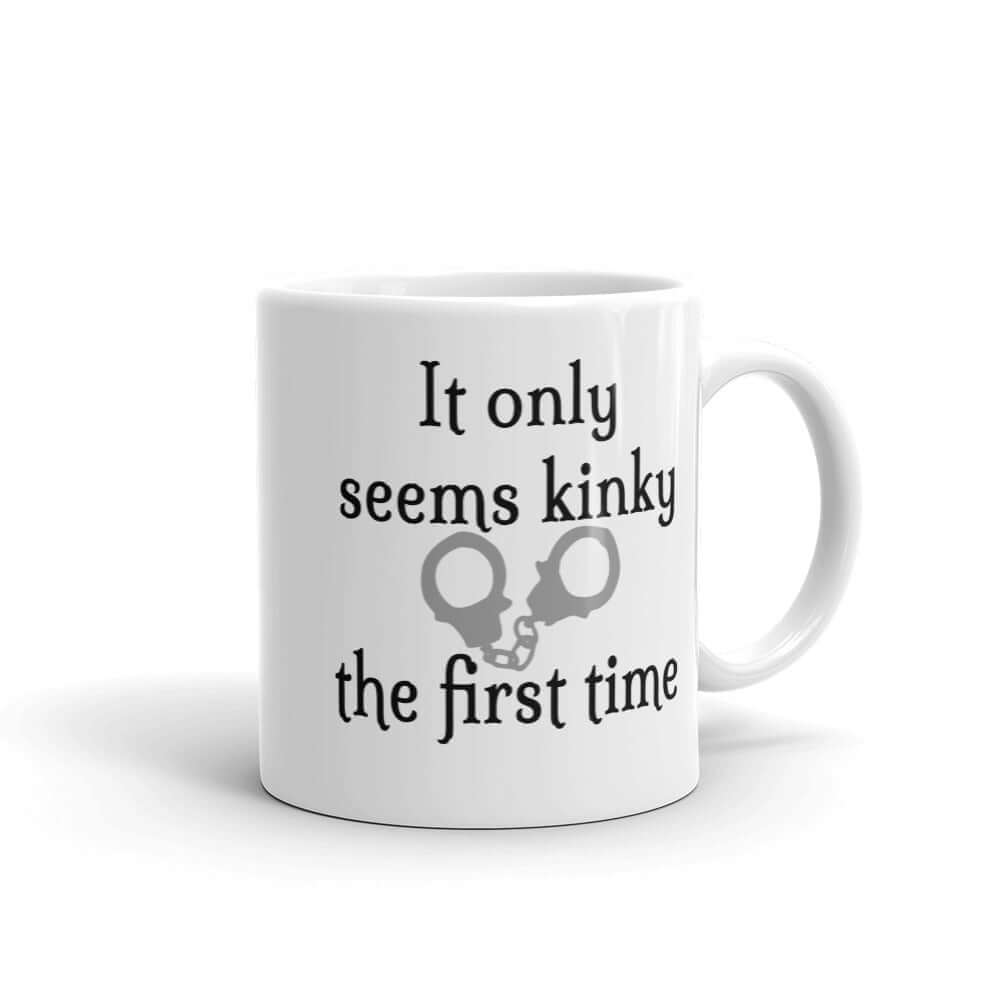 White ceramic coffee mug with the phrase It only seems kinky the first time printed on both sides of the mug. There is an image of handcuffs with the text.