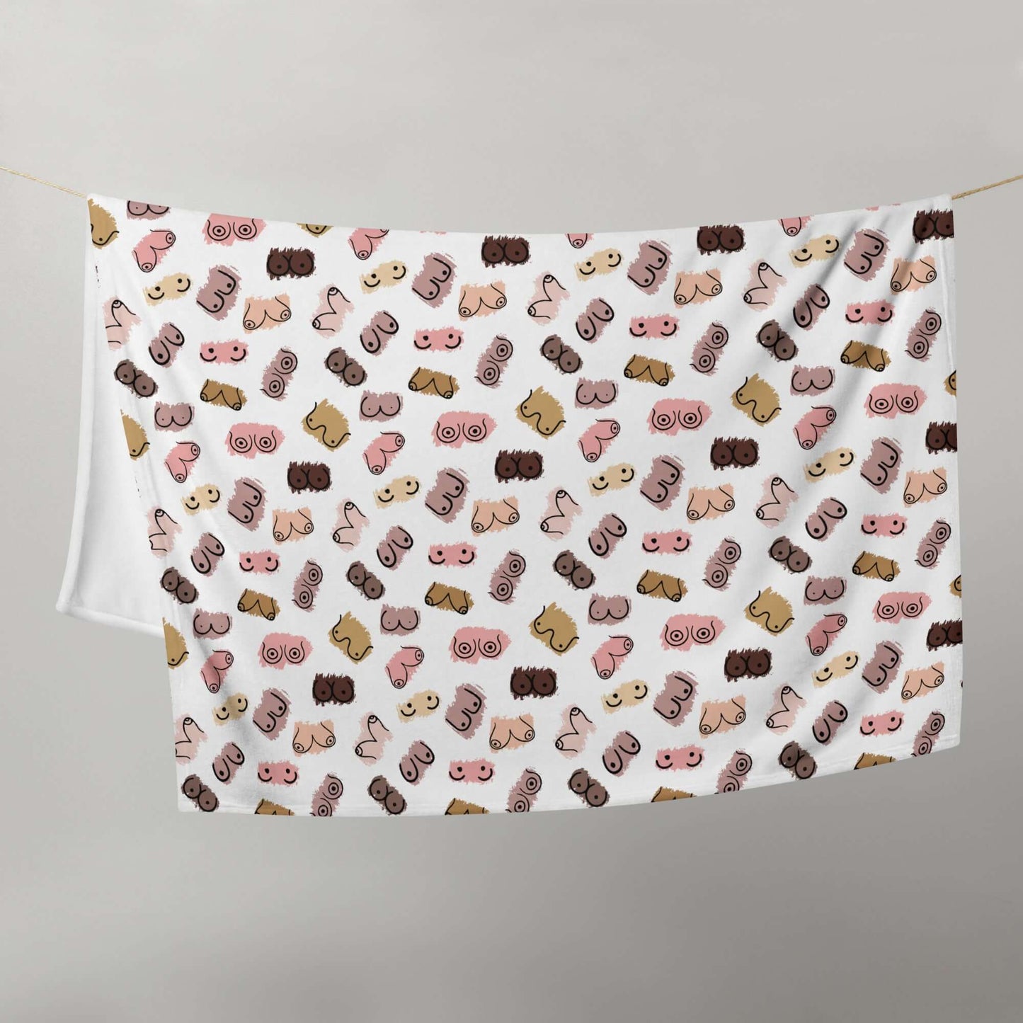 White fleece throw blanket with drawings of breasts in various skin tones printed all over.