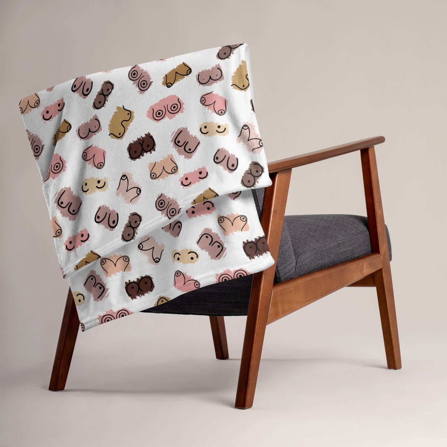 White fleece throw blanket with drawings of breasts in various skin tones printed all over.