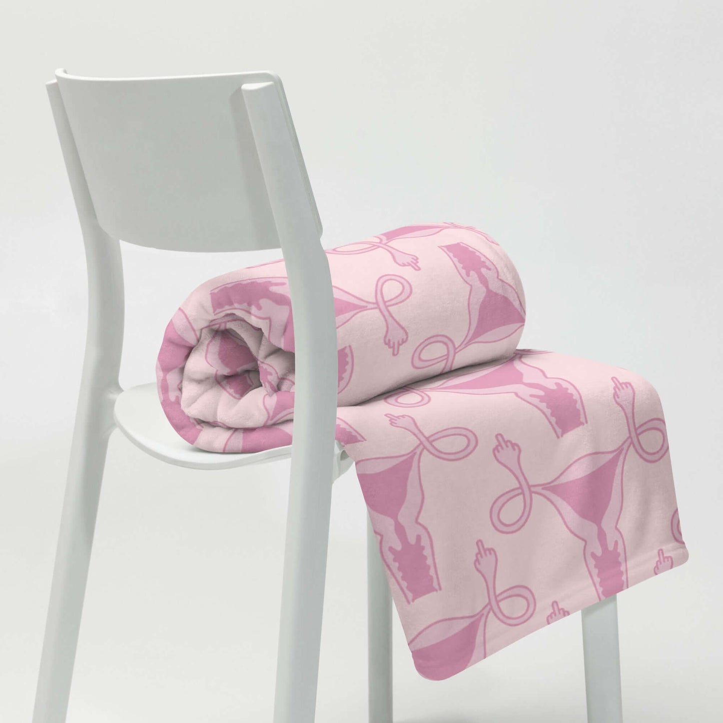Rolled Pink fleece throw blanket with pink uterus flipping middle finger graphic printed all over.