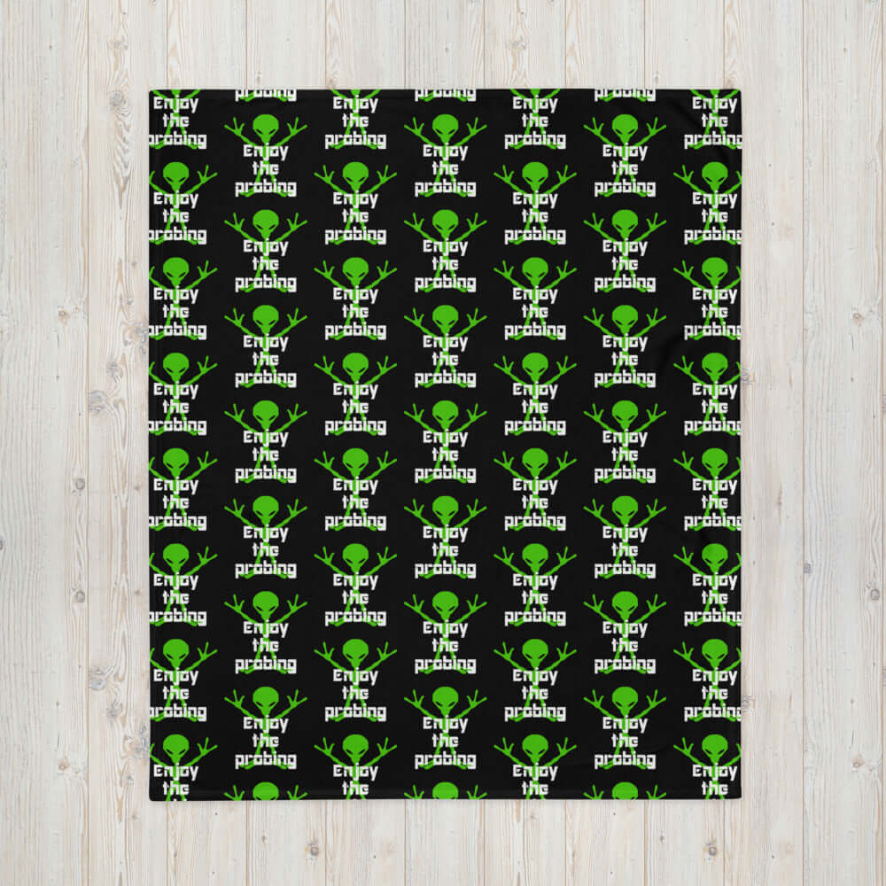Black fleece throw blanket with an image of an alien and the funny phrase Enjoy the probing printed all over the blanket.