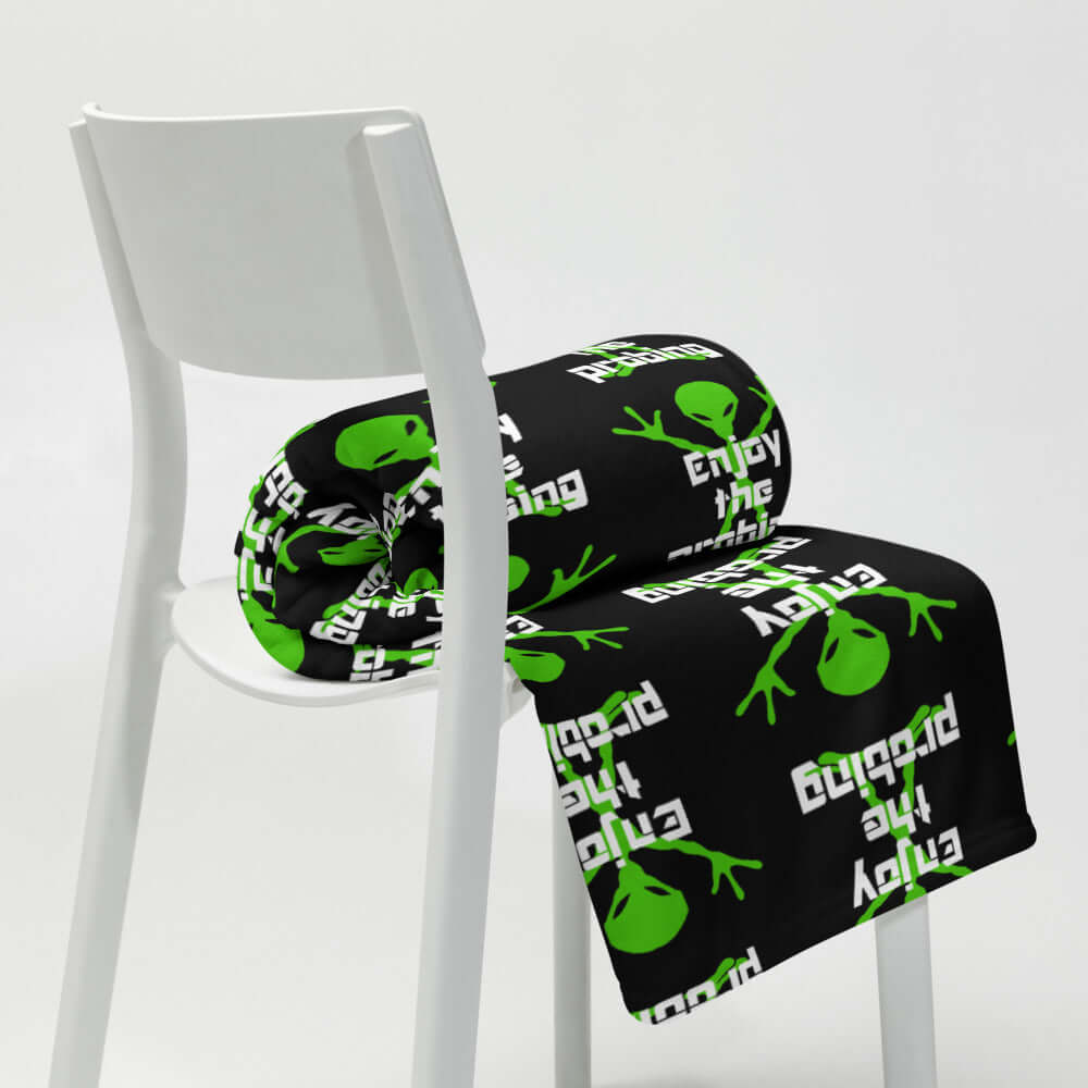 Black fleece throw blanket with an image of an alien and the funny phrase Enjoy the probing printed all over the blanket.