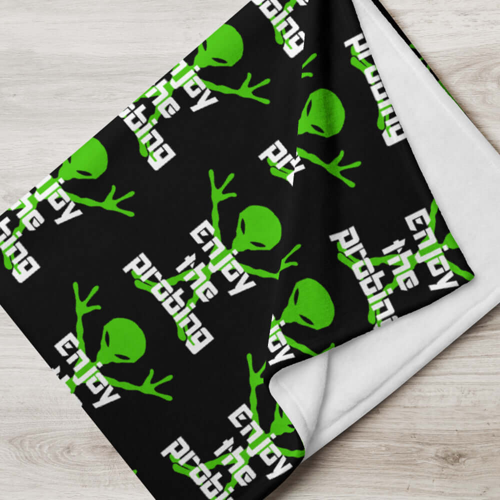Black fleece throw blanket with an image of an alien and the funny phrase Enjoy the probing printed all over the blanket.