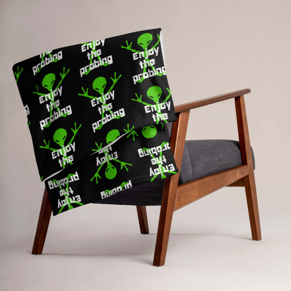 Black fleece throw blanket with an image of an alien and the funny phrase Enjoy the probing printed all over the blanket.