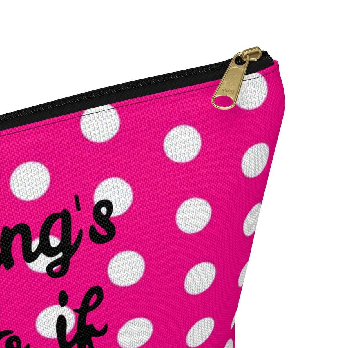 Pink and white polka dot zipper top pouch. The phrase Everything's a dildo if you're brave enough is printed in black on both sides of the pouch.