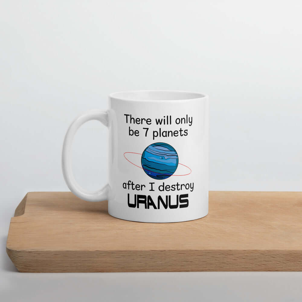 White ceramic coffee mug with an image of a planet and the phrase There will only be 7 planets after I destroy Uranus printed on both sides of the mug.