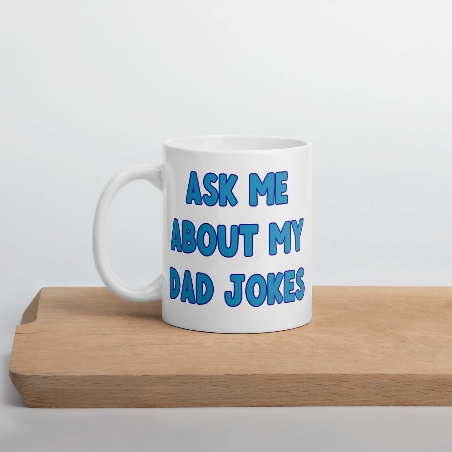White ceramic coffee mug with the words Ask me about my Dad jokes printed on both sides.