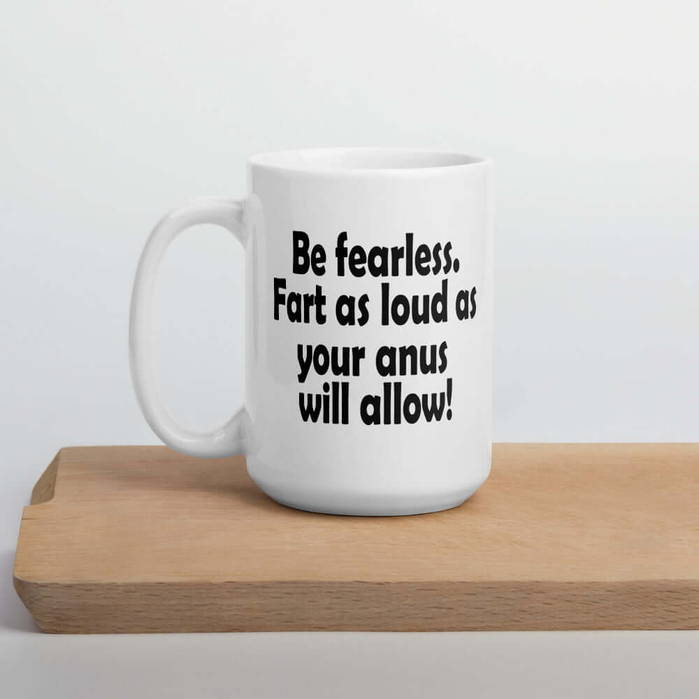 White ceramic coffee mug with the phrase Be fearless. Fart as loud as your anus will allow printed on both sides.