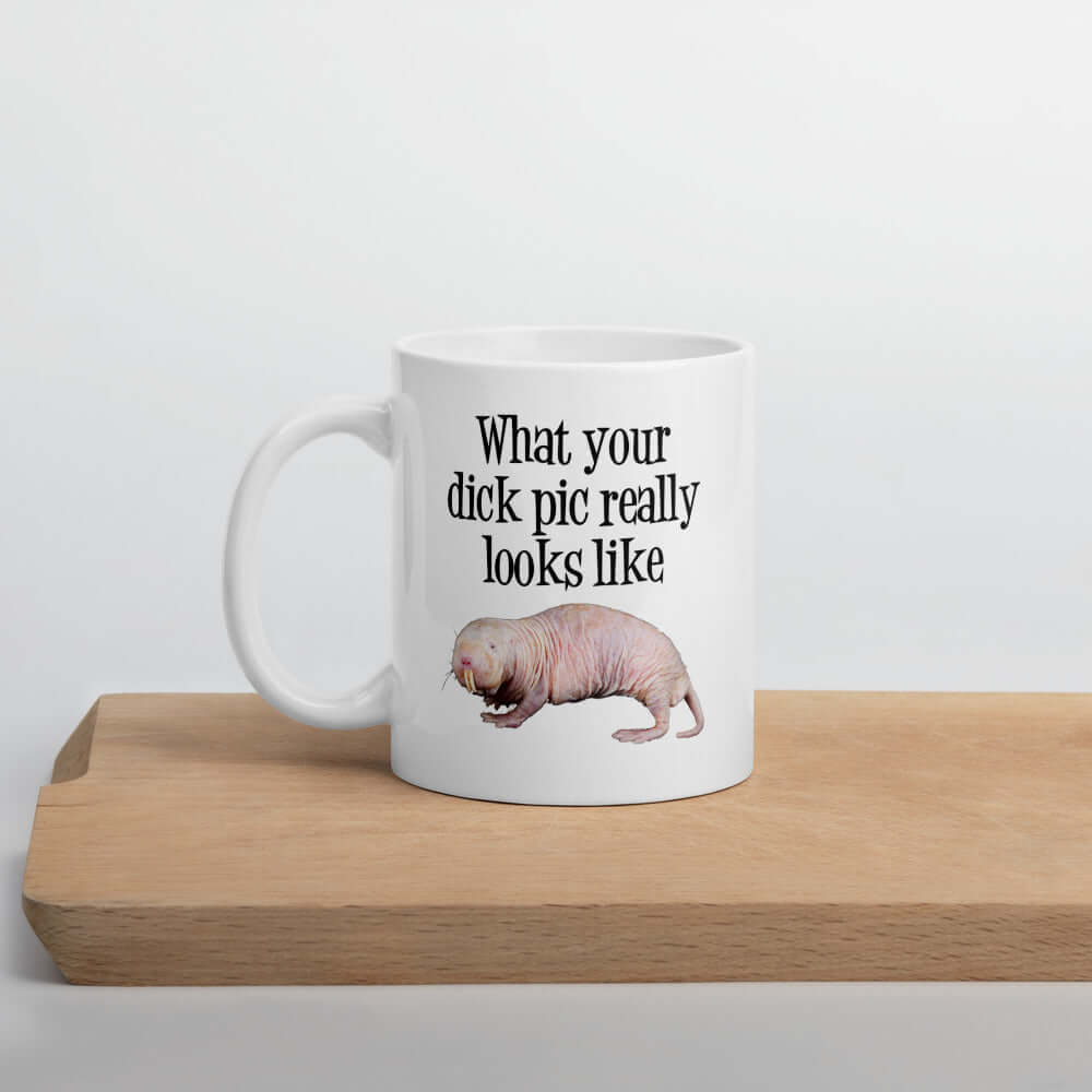 White ceramic coffee mug with the phrase What your dick pic really looks like printed on both sides. There is an image of a naked mole rat underneath with phrase. The graphics are printed on both sides of the mug.