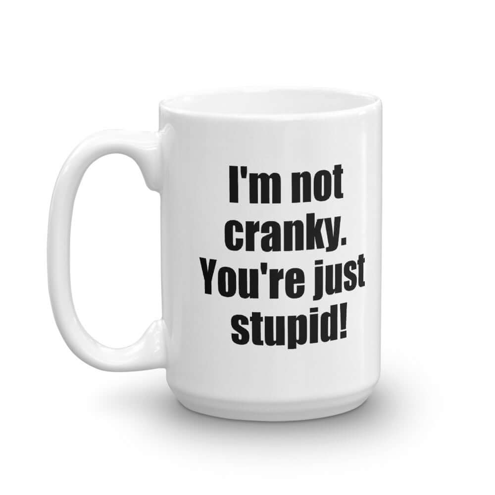 White ceramic coffee mug with the phrase I'm not cranky You're just stupid printed on both sides of the mug.