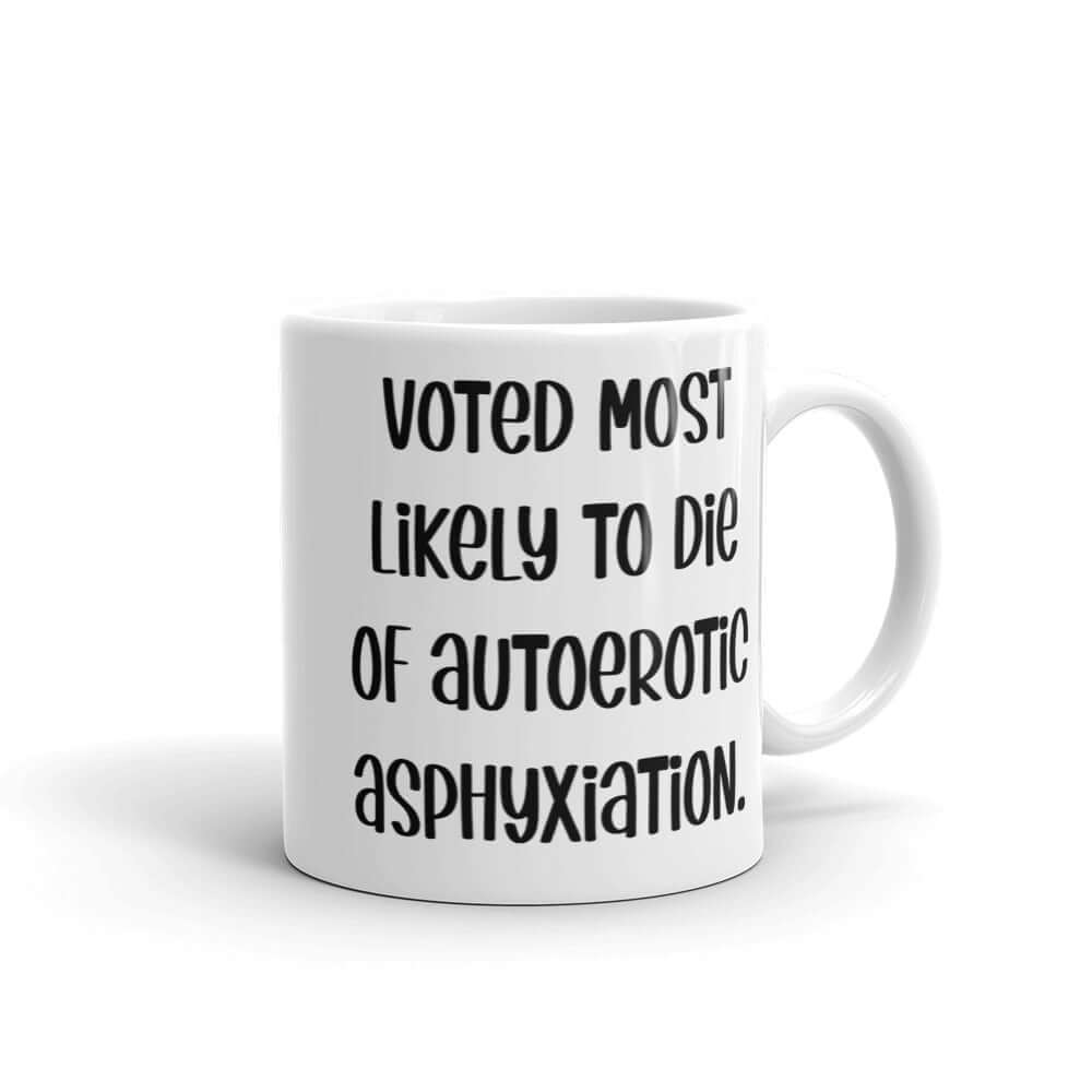 White ceramic coffee mug with the phrase Voted most likely to die of autoerotic asphyxiation printed on both sides.