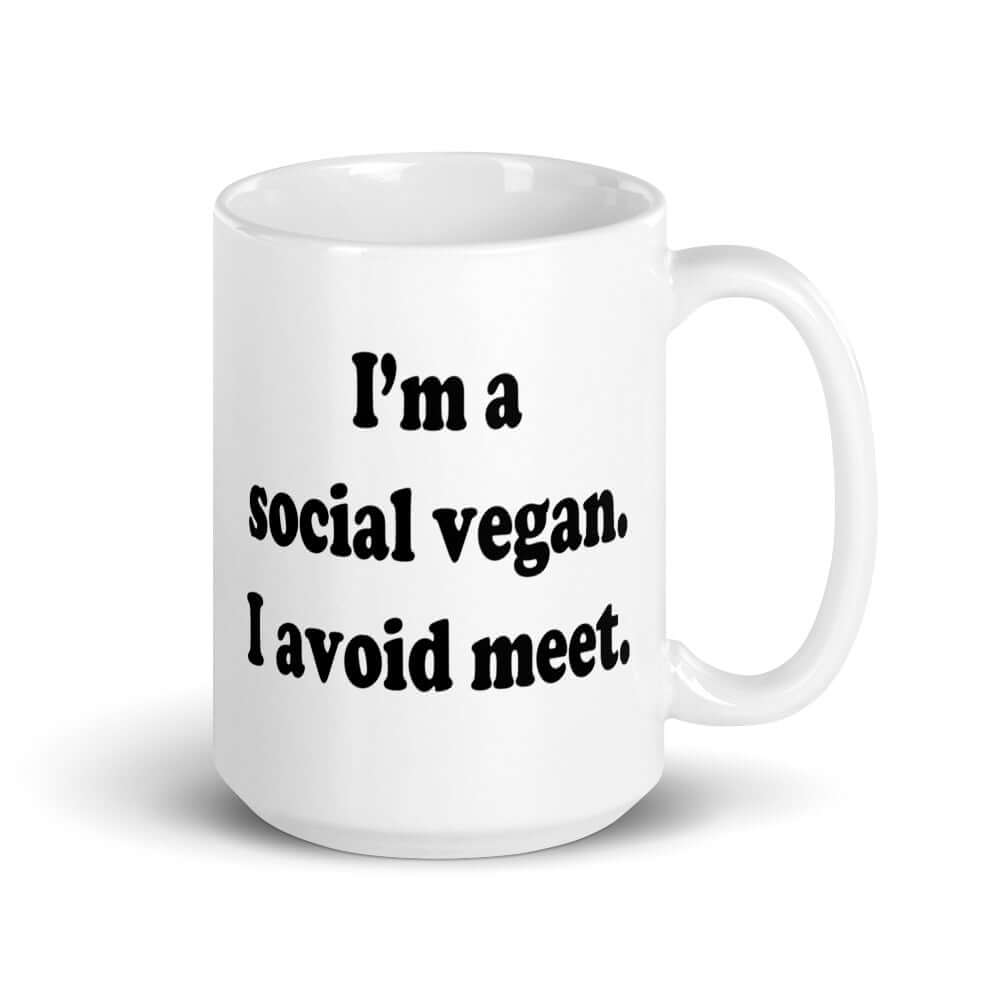 White ceramic coffee mug with the pun phrase I'm a social vegan, I avoid meet printed on both sides.