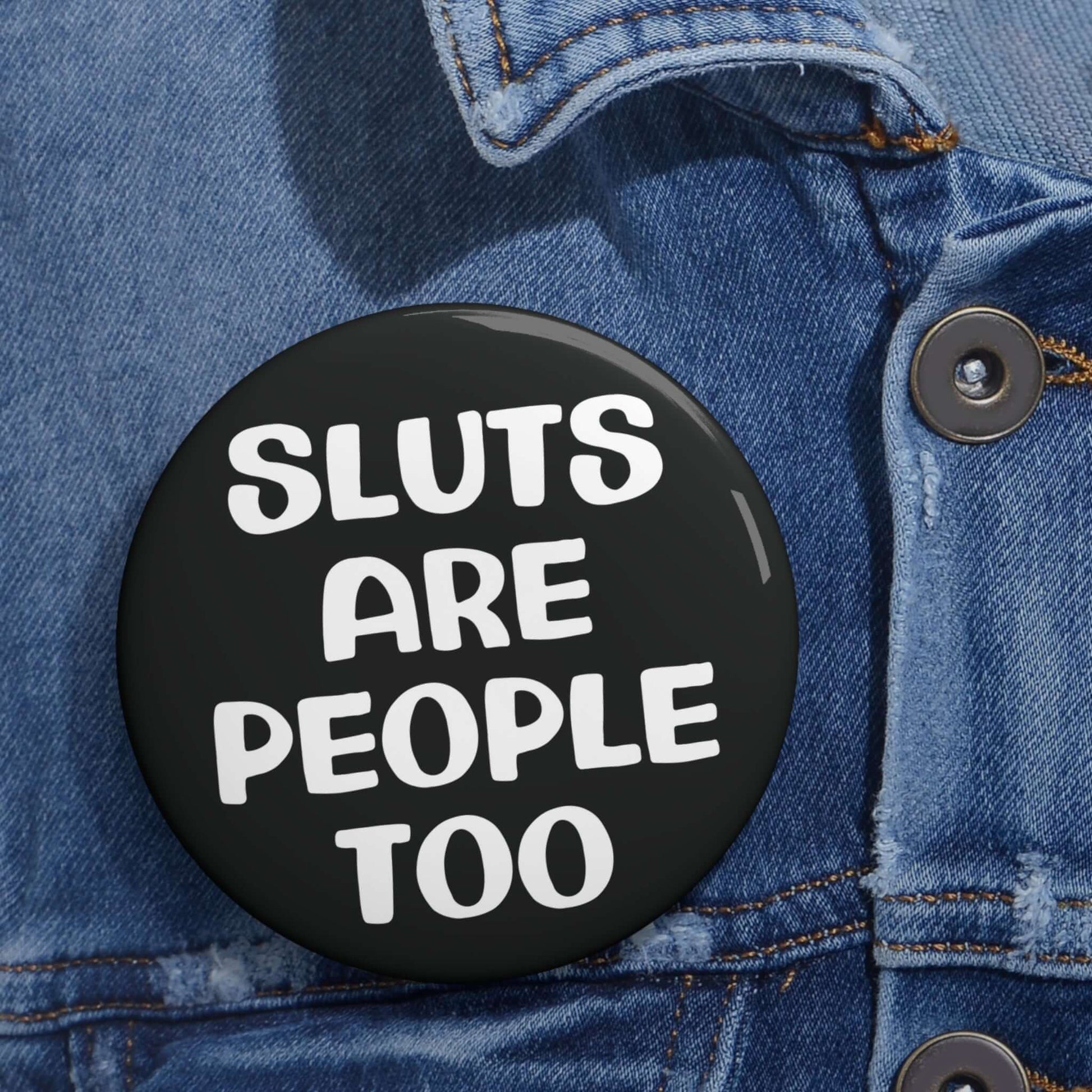 Black pinback button that says Sluts are people too.