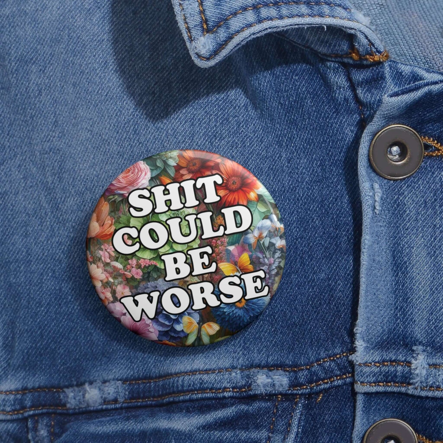 Pin-back button with floral background and text that says Shit could be worse.