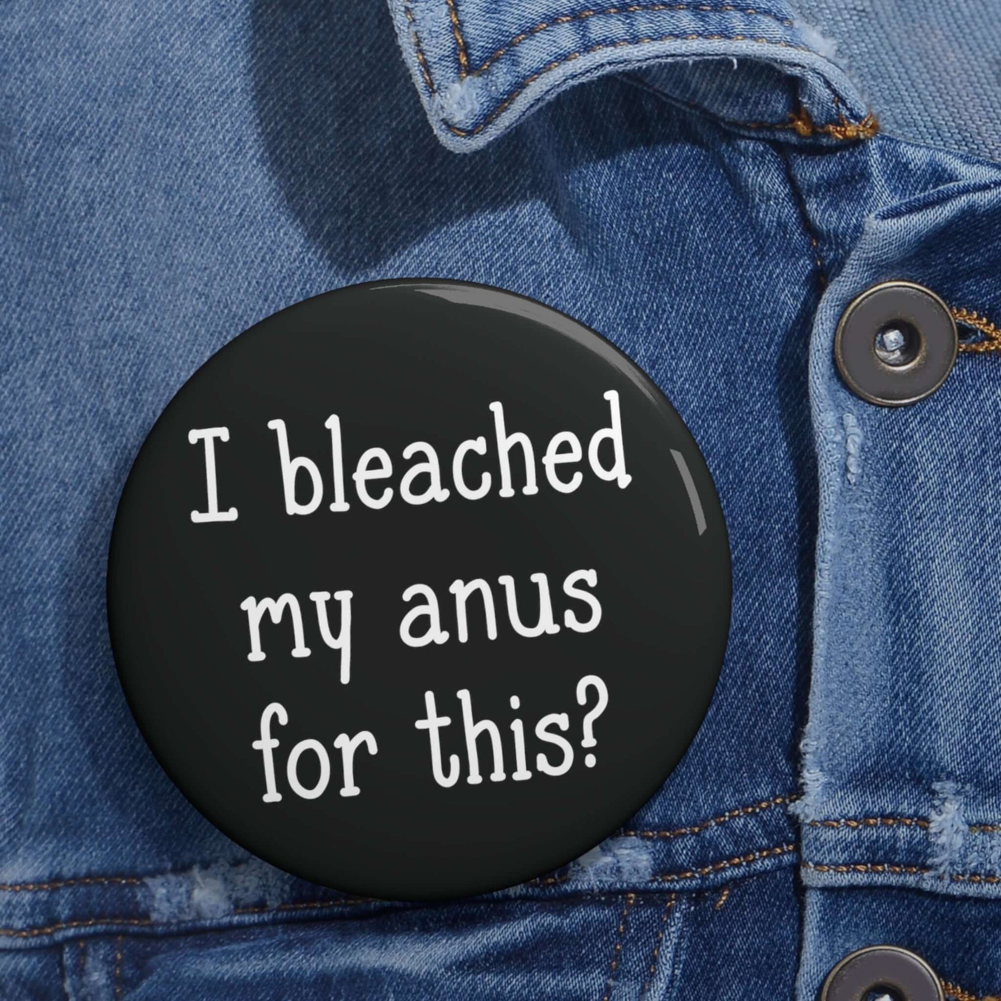 black pinback button with the words "I bleached my anus for this" printed on