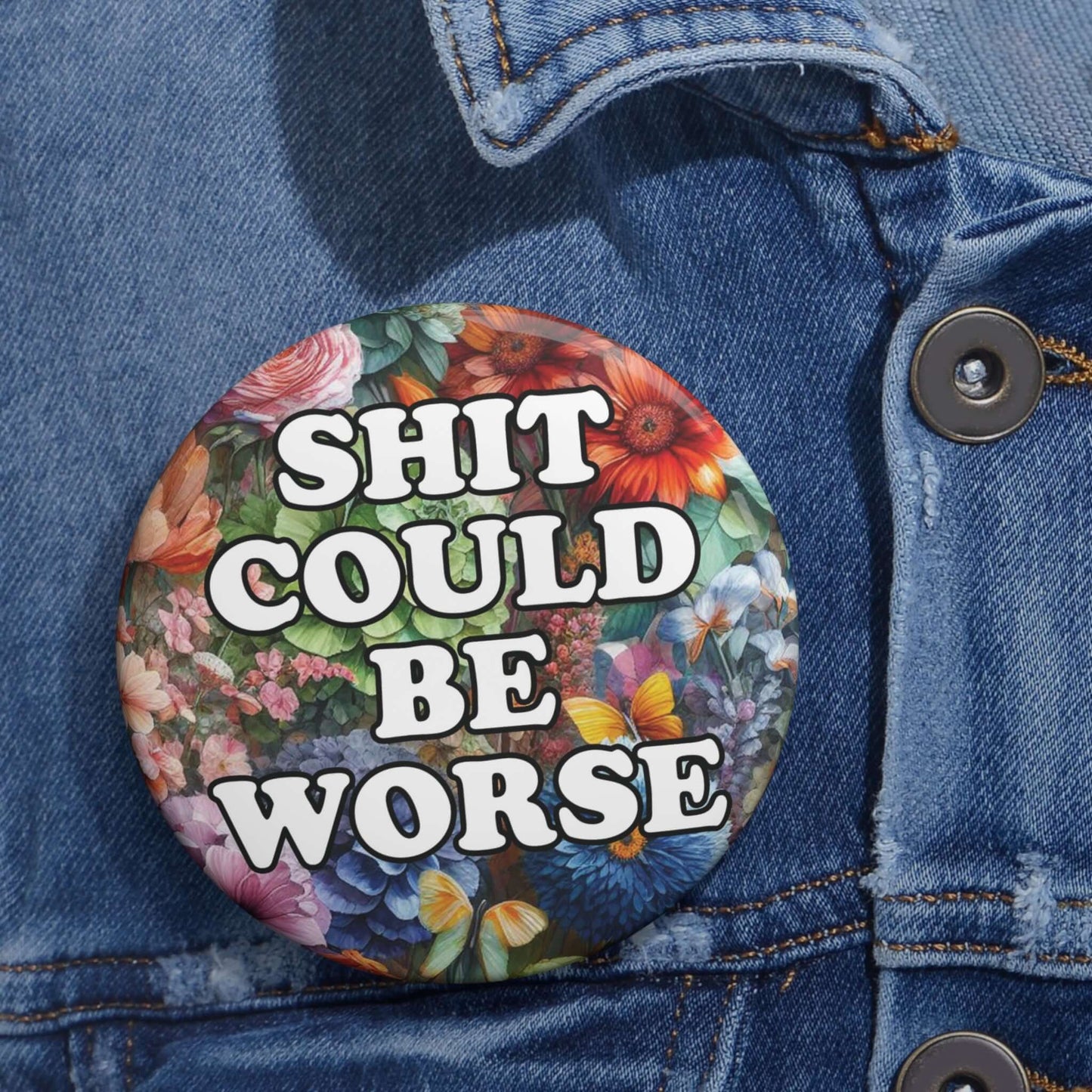 Pin-back button with floral background and text that says Shit could be worse.