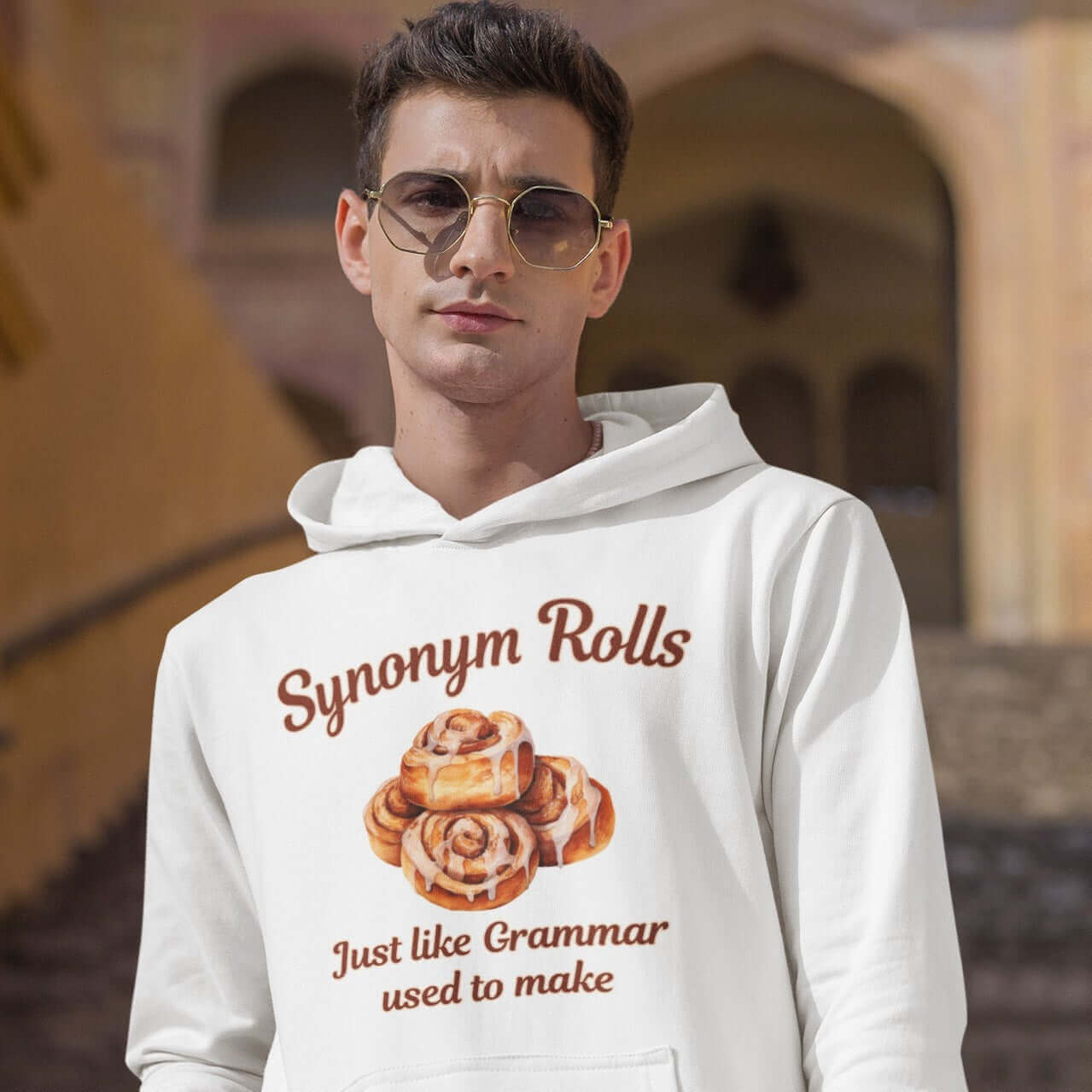 Man wearing funny cinnamon roll synonym grammar pun hoodie sweatshirt.